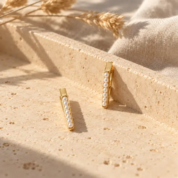 Slim Bar Pearl Earrings styled on a display