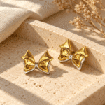 Pair of elegant gold plated bow earrings on a white background