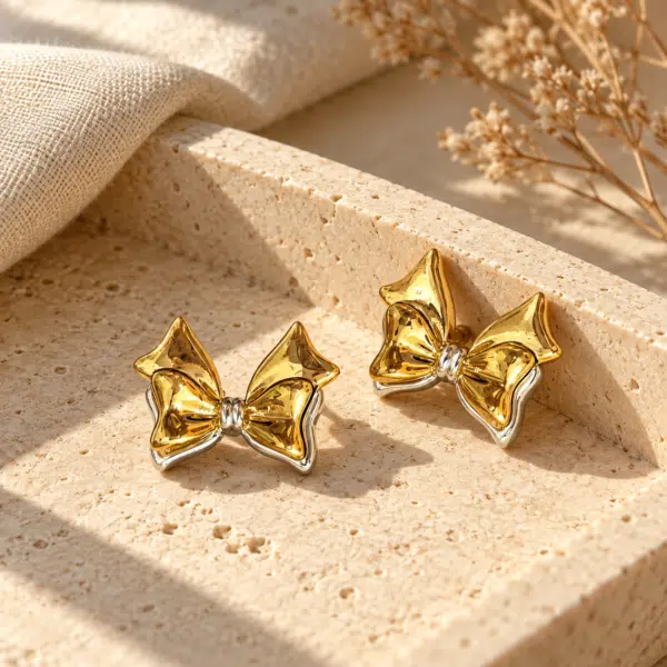 Pair of elegant gold plated bow earrings on a white background