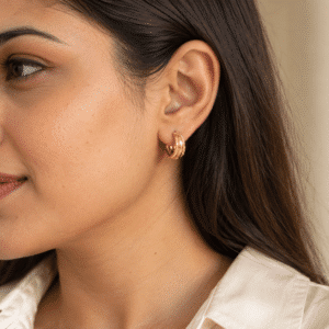 Woman wearing gold plated hoop earrings on her ear