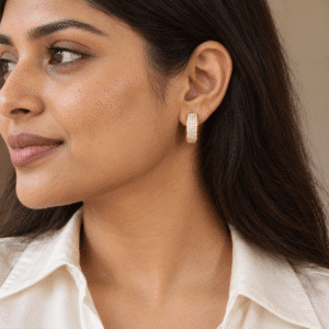 A woman wearing elegant gold-plated crystal hoop earrings