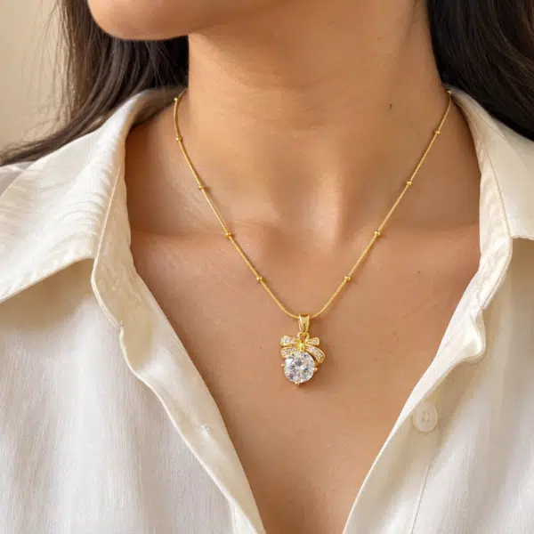 A woman wearing a delicate Bow Solitaire Golden Necklace on a white shirt