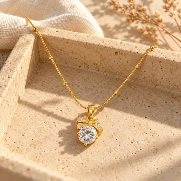 Bow Solitaire Golden Necklace showing a sparkling central stone with gold ribbon detail