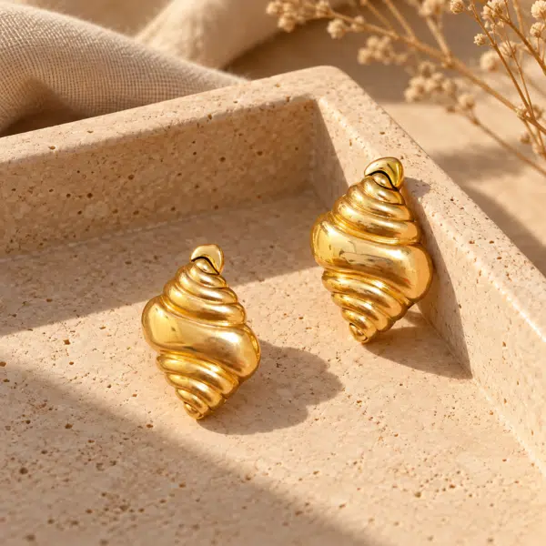 Conch Shell Gold Earrings styled on a display