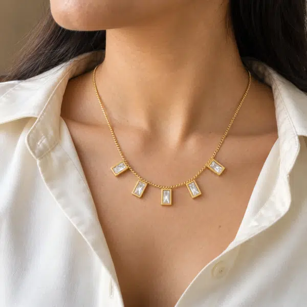 Elegant model wearing a gold baguette stone necklace with white shirt