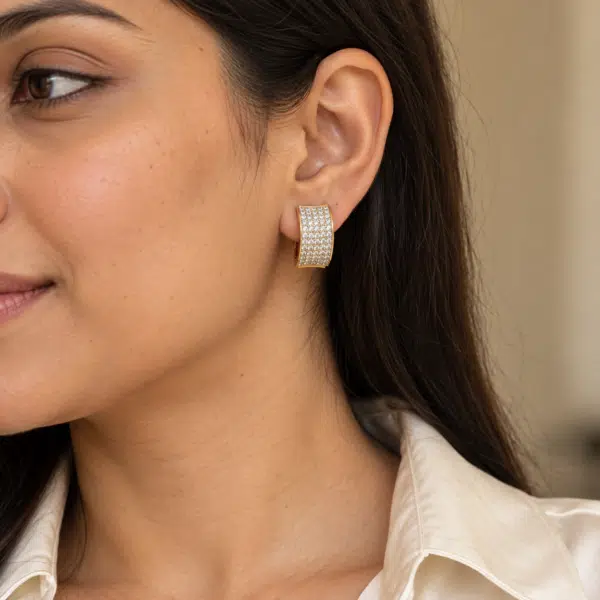 Wide Pavé Gold-Tone Hoop Earrings worn by a model