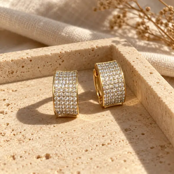 Wide Pavé Gold-Tone Hoop Earrings styled on a display