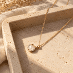 Gold plated necklace with pearl pendant on white background