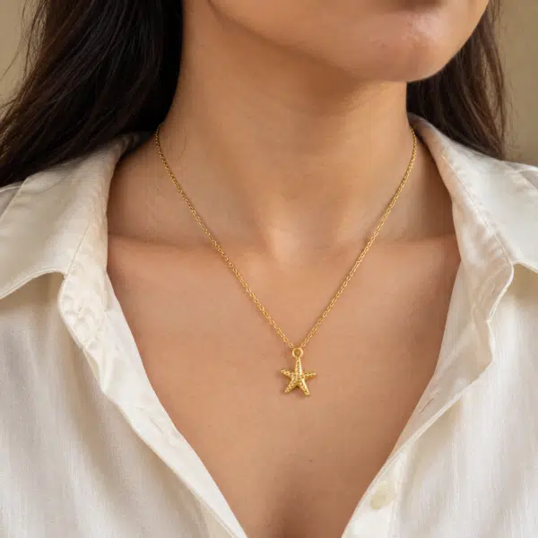 Close-up of the Maris Gold Starfish Necklace worn on a neck