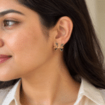 Close-up of a woman wearing black bow gold plated earrings