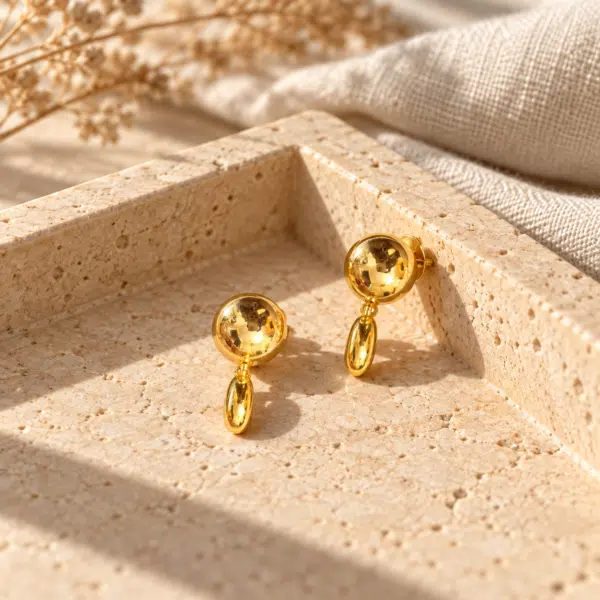 Front view of spherical gold drop earrings