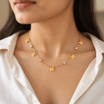 Woman wearing gold plated butterfly necklace with shirt