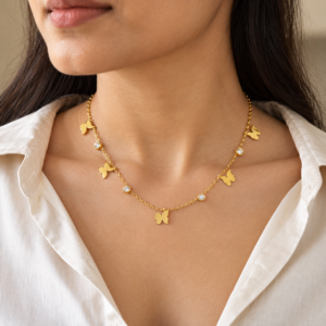 Woman wearing gold plated butterfly necklace with shirt