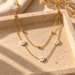 Layered gold necklace featuring white floral petals
