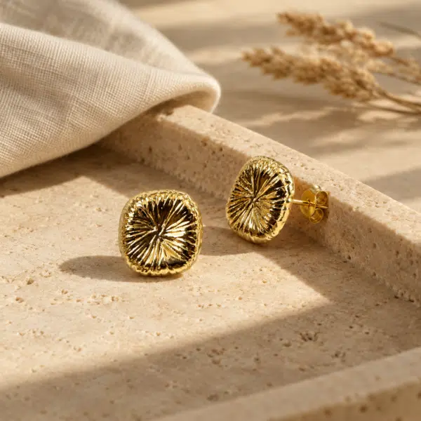 Solaris Gold Studs styled on a display