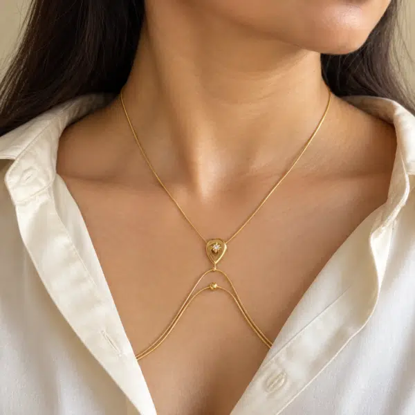 Model wearing gold-plated body jewelry with teardrop motif